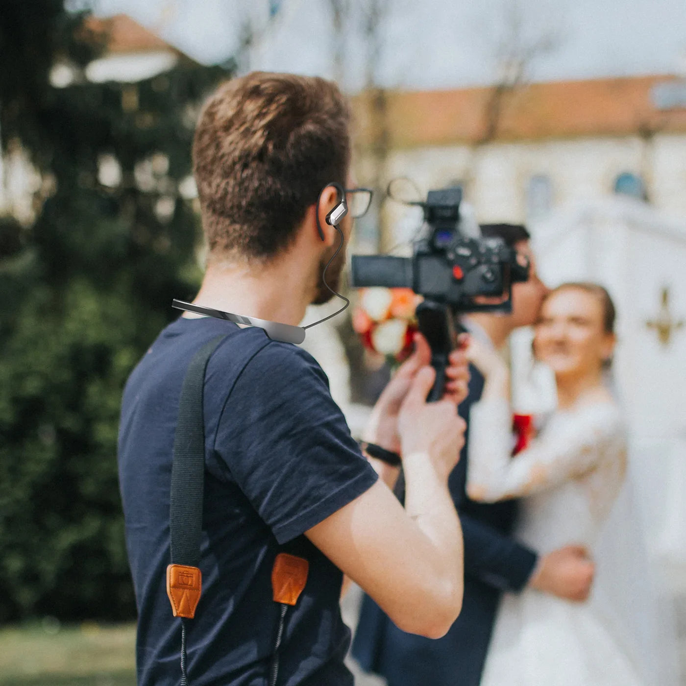 A videographer using a SYNCO Xtalk S headset while filming a wedding.