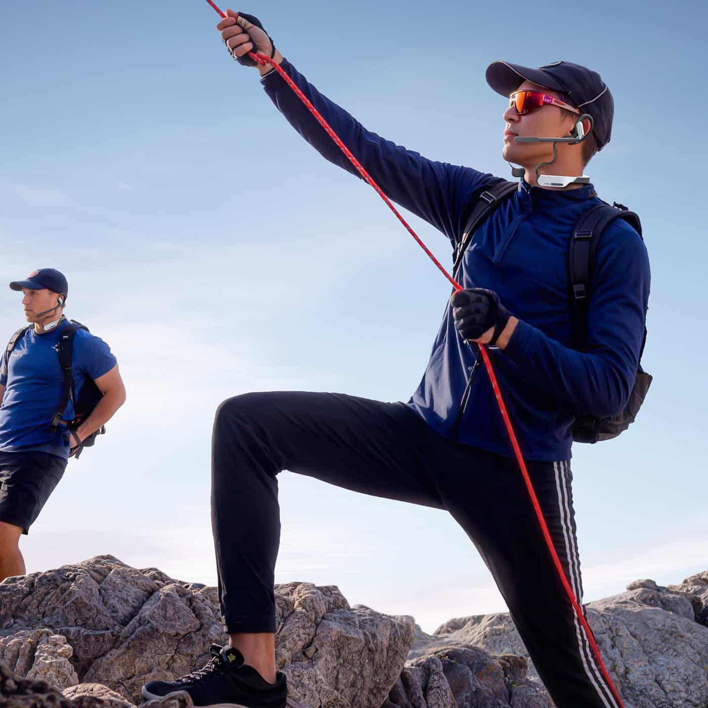 Two rock climbers wear the SYNCO Xtalk S neckband intercom headset for hands-free communication.