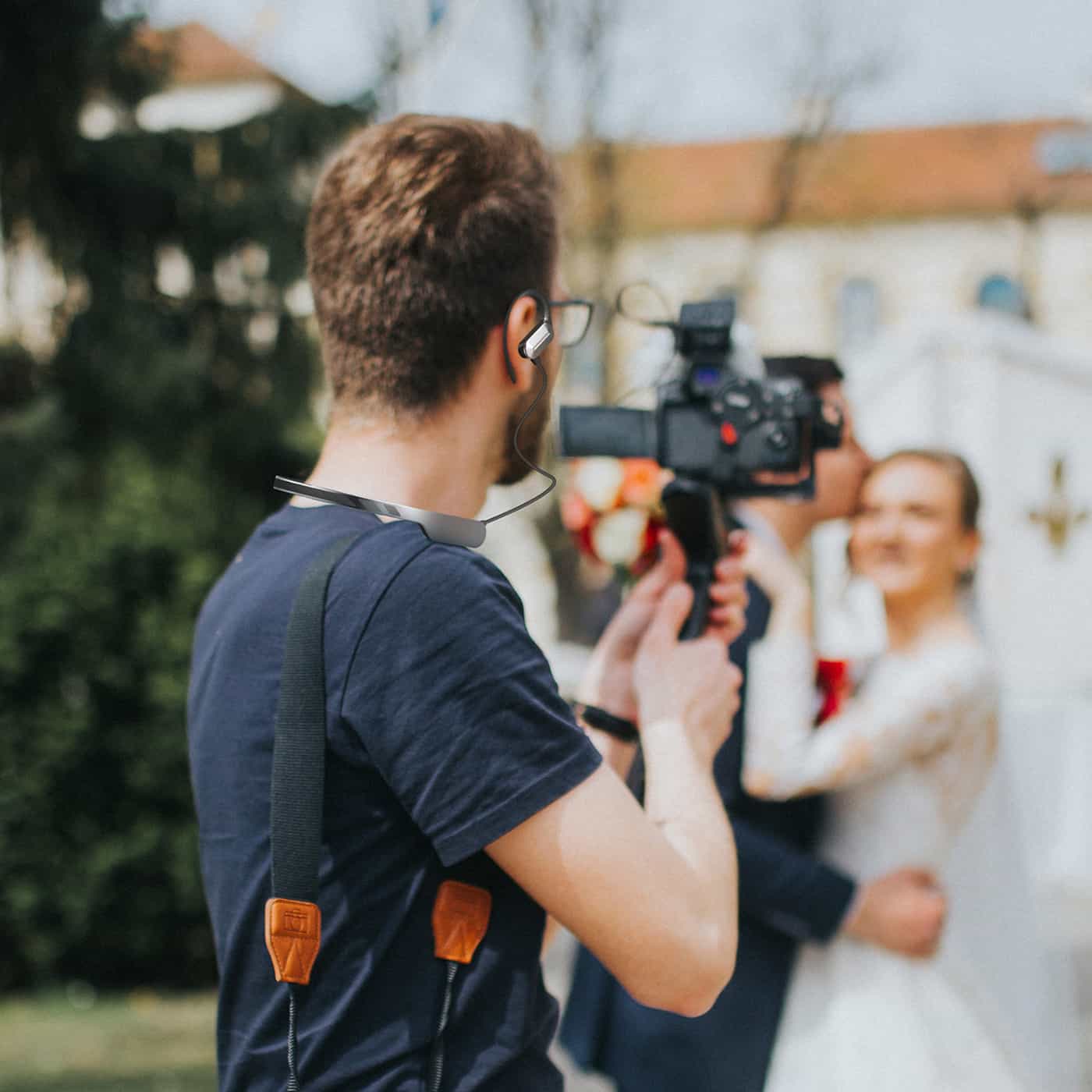 A videographer using a SYNCO Xtalk S headset while filming a wedding.